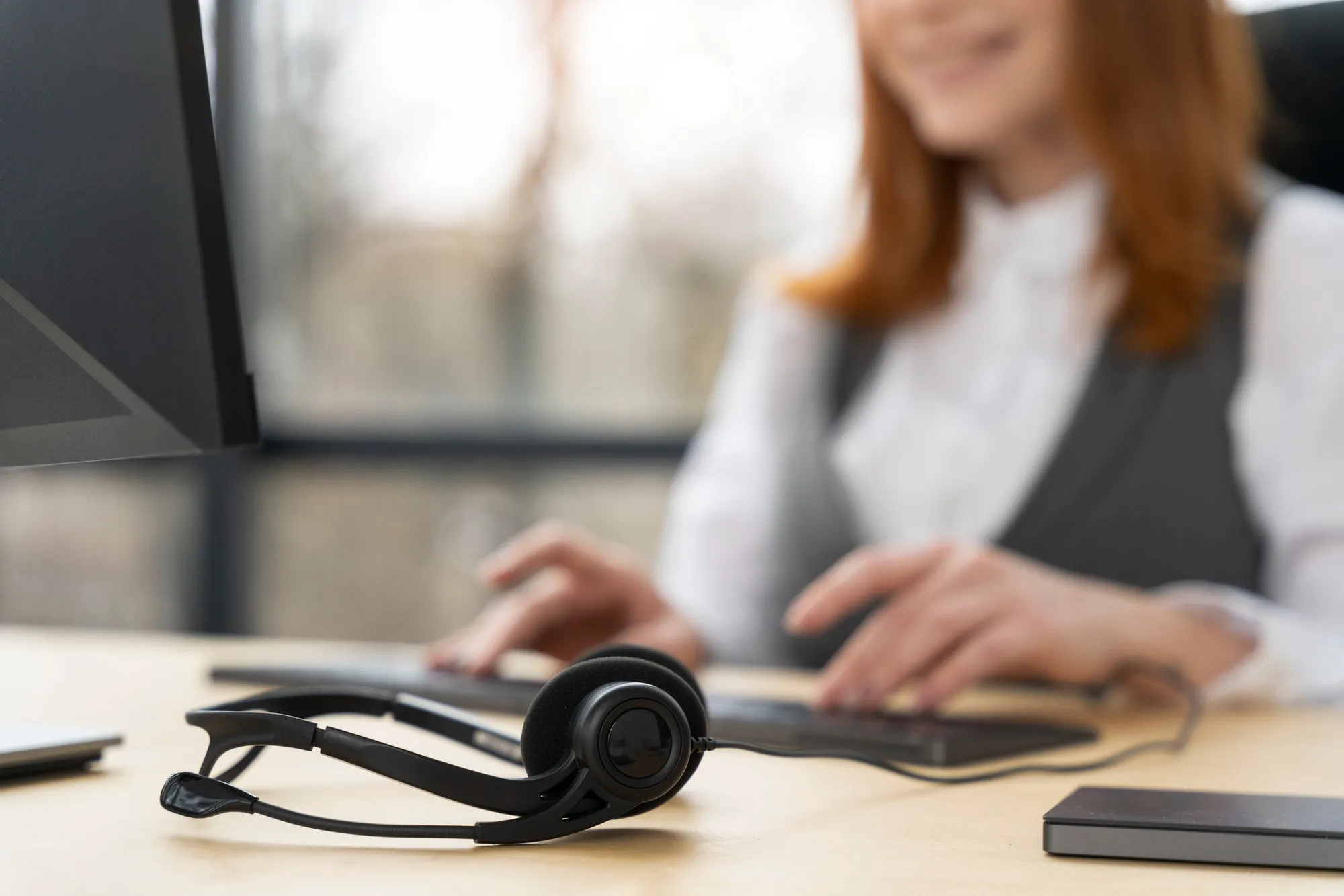Mötesbokare vid skrivbordet med headset och dator
