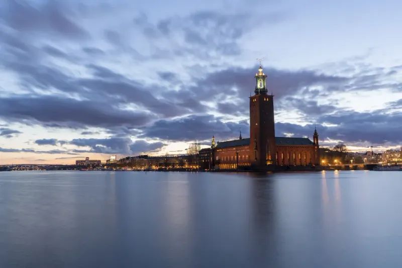 Stockholms stadshus vid vattnet i skymningen